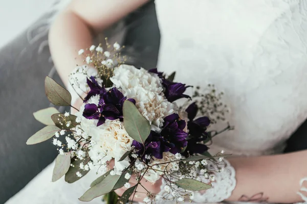 Partial view of bride in white dress with beautiful bridal bouquet in hands — Stock Photo