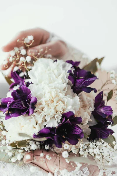 Partial view of bride in white dress with beautiful bridal bouquet in hands — Stock Photo