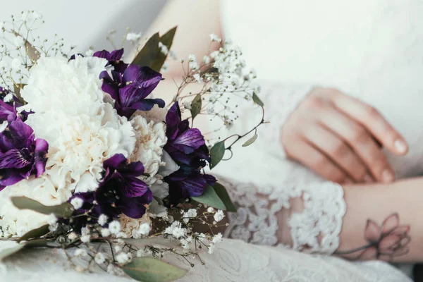 Partial view of bride in white dress with beautiful bridal bouquet — Stock Photo