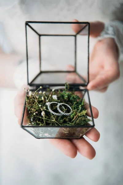 Tiro recortado de novia en vestido blanco con anillos de boda en caja en las manos - foto de stock