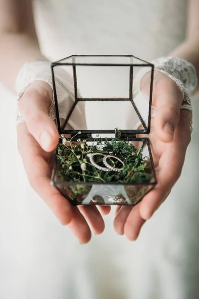 Tiro recortado de novia en vestido blanco con anillos de boda en caja en las manos - foto de stock