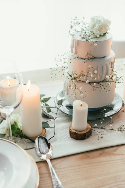 Close up view of stylish table setting with candles and wedding cake for rustic wedding — Stock Photo