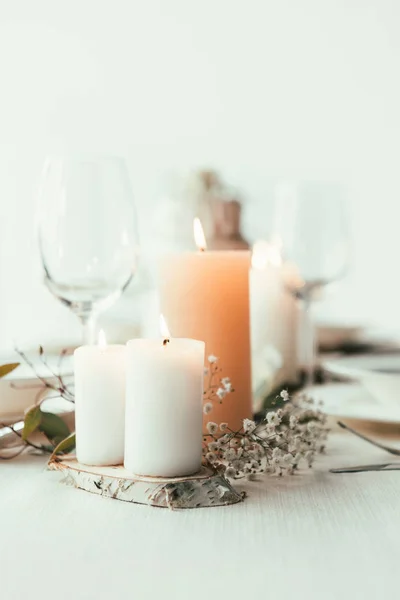 Vista de cerca de la elegante mesa con velas, gafas de vino y flores para la boda rústica - foto de stock