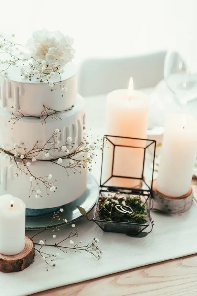 Nahaufnahme der stilvollen Tischdekoration mit Kerzen und Trauringen für die rustikale Hochzeit — Stockfoto