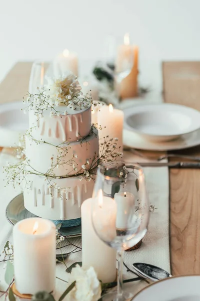 Vista de cerca de la elegante mesa con velas y pastel de boda para la boda rústica - foto de stock