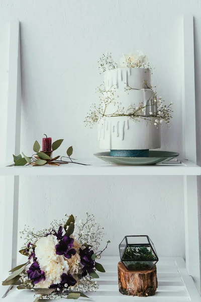 Vista de cerca de la torta de boda arreglada, ramo de novia y anillos de boda para la boda rústica - foto de stock