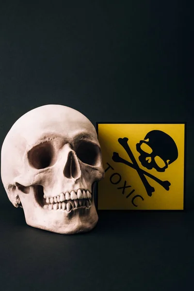 Crâne et signe toxique jaune isolés sur noir — Photo de stock