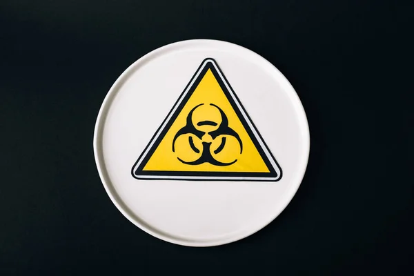 Top view of plate with biohazard sign isolated on black — Stock Photo