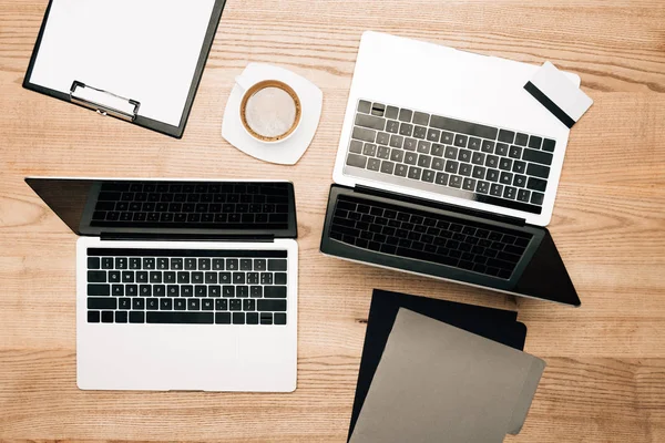 Draufsicht auf Laptops, Kreditkarte und Kaffee auf Holztisch — Stockfoto