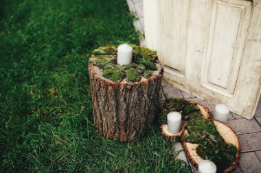 Kharkov / Ukrayna - 05 / 06 / 2015Rustik stil düğün dekoru. Bir mum yosunlu bir kütüğün üzerinde duruyor..