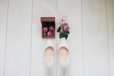 Odessa / Ukrayna - 05 / 20 / 2017 Düğün Süslemeleri. Taze çiçeklerden yapılmış düğme deliği olan klasik düğün ayakkabıları.