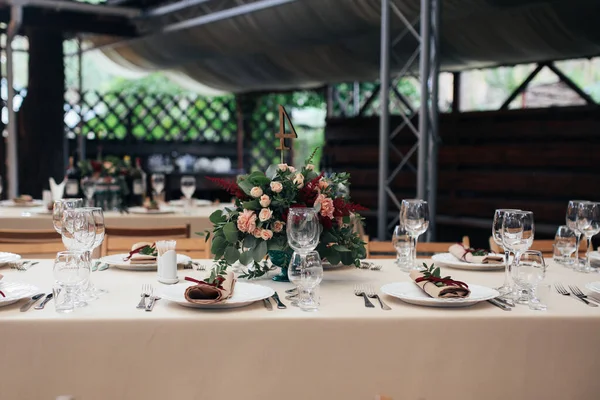 キエフ ウクライナ 2017年9月2日結婚式の装飾 素朴な結婚式のテーブルの設定 プレート フォーク メガネ ナイフ ベージュ生地のテーブルクロス テーブルの真ん中に花で装飾 — ストック写真