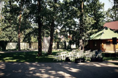 Kiev / Ukrayna - 08 / 25 / 2018 Düğün Süslemeleri. Ağaçlar ve beyaz sandalyeler arasındaki kurdelelerden yapılmış şık bir düğün kemeri.