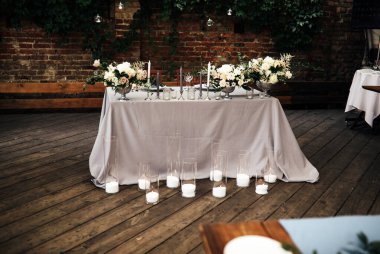 Kiev / Ukrayna - 06 / 22 / 2018 - düğün dekoru. Taze çiçeklerle taşralı gri düğün odası dekorasyonu. Bir sürü mum ve klasik şamdanlı masa..