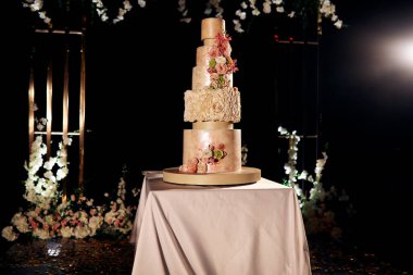 Rivne / Ukrayna - 07 / 15 / 2018 - düğün dekoru. Fiyakalı bir geometrik düğün kemerinin arka planında beş katlı muhteşem düğün pastası.