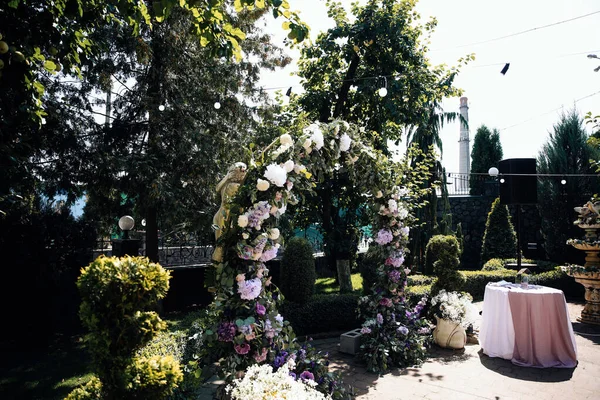 Khmelnitsky ウクライナ 2009 結婚式の装飾 紫と緑の花と古典的なスタイルで新鮮な花のシックな結婚式のラウンドアーチ ギリシャの美しい像と白い椅子 — ストック写真