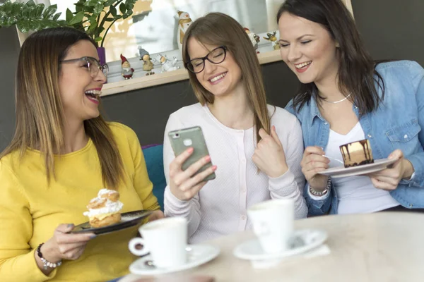 Yetişkin bir kız arkadaşları onun yeni erkek arkadaşı bir smartphone/a güzel gülümseyen kız fotoğrafı yeni erkek arkadaşı bir fotoğrafını arkadaşlarına gösterir