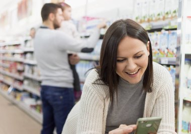 raf bir süpermarkette annesi yanında ürünleri olduğunu diğerleri bir akıllı telefon hesaplama öncesinde aile seçer