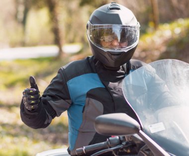 Şehir dışında bir yolculuğa bir motosiklet scooter olgun bir erkek rides