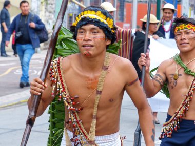 Cuenca, Ekvador - 21 Eylül 2019: Halk dansçıları Cuenca kentindeki geçit töreninde Ekvador Amazonia, Pastaza eyaletinden Shuar kabilesinin yerli kültürünü temsil etmektedir..