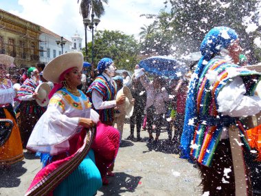Cuenca, Ekvador - 2 Mart 2019: Karnaval sırasında geçit töreni. Halk dansçıları Cuenca şehrinin tarihi merkezi ve ana meydanındadır. Herkese köpük sıkılmış.