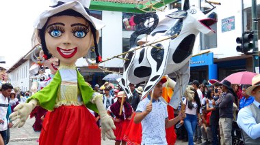 Cuenca, Ekvador-11 Nisan 2019: Azuay eyaleti için tipik kostümlü dev mankenler ve halk dansçıları - cholas cuencanas, müzisyenler ve havai fişek geleneksel geçit töreninde 