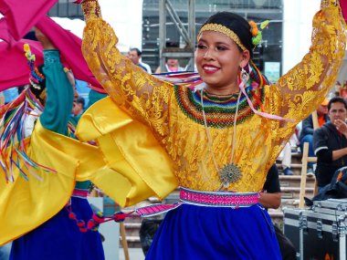 Cuenca, Ekvador - 21 Aralık 2019: Ekvador Kapak Raymi kutlamasında Otavalo Canton (Imbabura Eyaleti) rengarenk kostümlü tanımlanamayan genç bayan dansçı