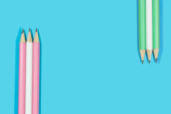 Pencils of pink, white and green on blue background.  Concept ed — Stock Photo, Image