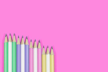 Multicolor kalemler pembe bir arka plan üzerinde