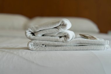 Beyaz havlu seti ve modern otel yatakta