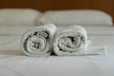 Beyaz havlu seti ve modern otel yatakta