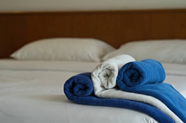 Beyaz ve mavi havlu otel yatak odasında yatakta