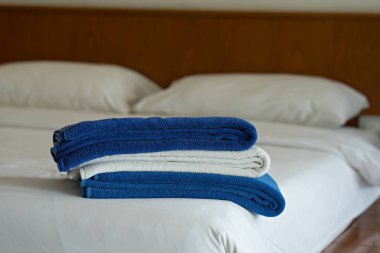 Mavi ve beyaz havlu otel yatak odasında yatağın üzerine