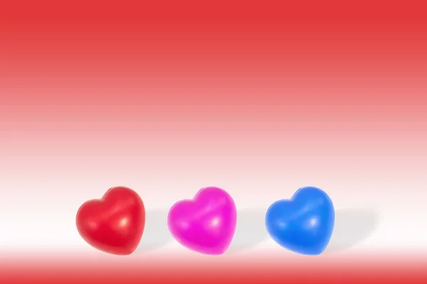 Corazón rojo, rosa, azul sobre fondo rojo con espacio para copiar . — Foto de Stock