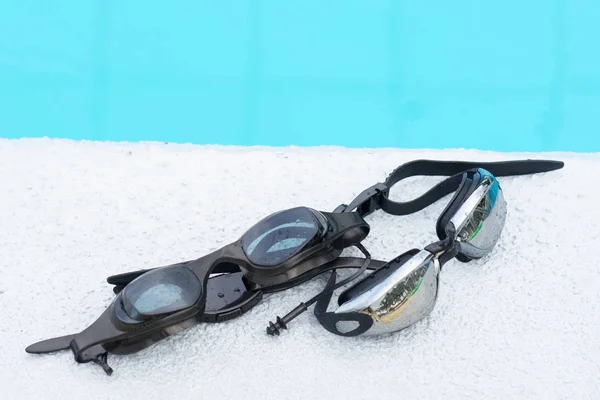Dos gafas para nadar negro en el borde de la piscina —  Fotos de Stock