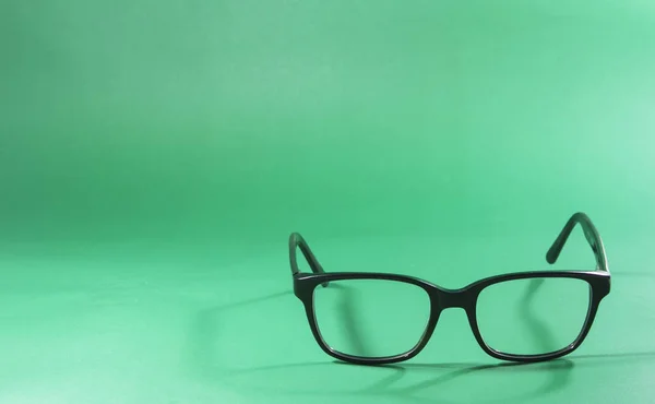 Óculos pretos Em um fundo verde — Fotografia de Stock