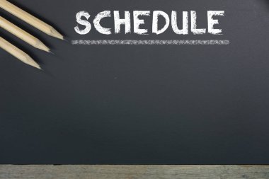 Kılavuz zaman masaya Siyah Kara tahta arka plan ile zamanlama