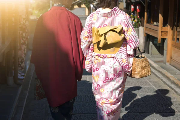 Женщины в традиционных японских кимоно ходят в храме с солнцем — стоковое фото