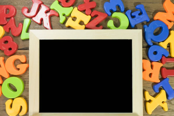 Farbige Buchstaben oder Alphabet und Zahl mit schwarzer Tafel auf Holz — Stockfoto