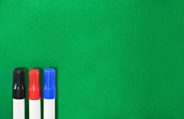 Rotulador Pen negro, rojo, azul sobre fondo verde . — Foto de Stock