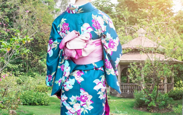 Kvinna som bär Kimono traditionella Japan promenader på offentliga park. — Stockfoto