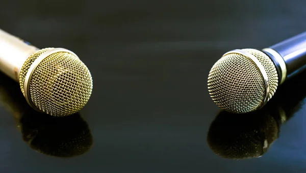 Gold and black Microphones on black background.