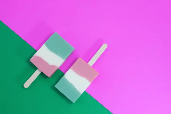 Ice cream sticks on pink and green on background — Stock Photo, Image