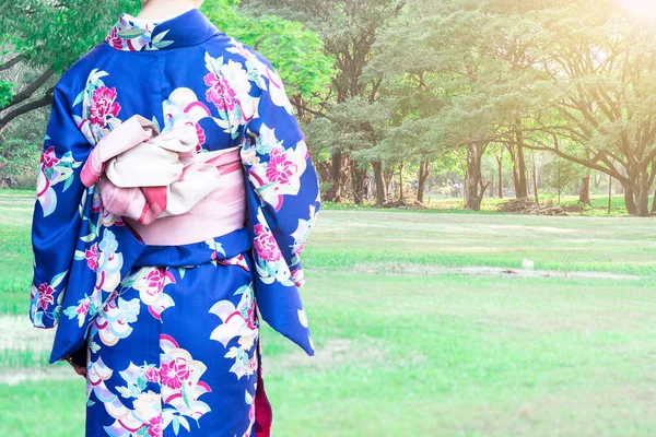 Kvinna som bär Kimono traditionella Japan promenader på offentliga park. — Stockfoto