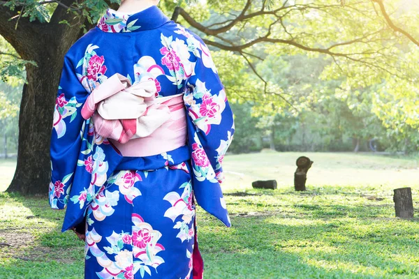 Женщина в традиционной японской одежде кимоно ходит в общественном парке . — стоковое фото