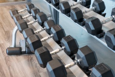 Satır siyah Dumbbells bir çelik raf. Egzersiz eğitim ve fitness spor salonu konsept. 