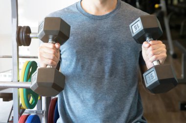 Bir adam egzersiz acemi vasıl jimnastik salonu kas için dumbbell ile