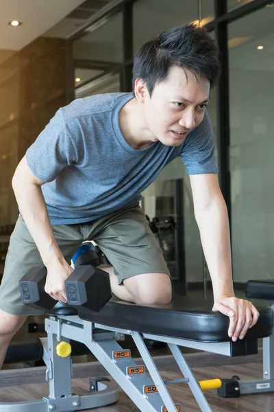 Un principiante de entrenamiento de hombre con mancuerna para los músculos en el gimnasio — Foto de Stock