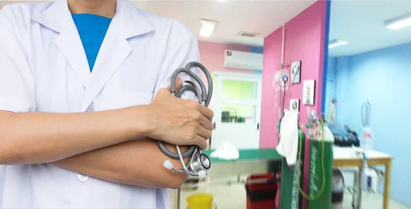 Arzt hält Stethoskop mit verschwommenem Krankenhaus. — Stockfoto