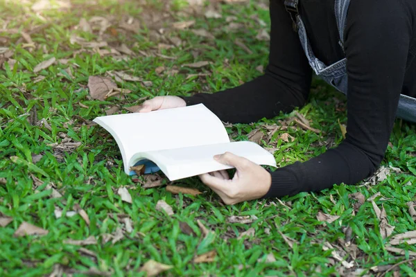 Jeune femme lisant un livre dans le jardin à la maison — Photo